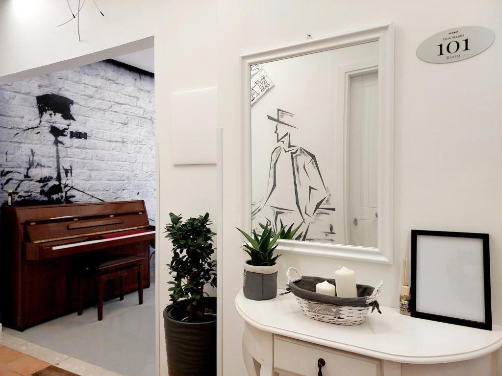 - un salon avec un miroir et un piano dans l'établissement Don Mario Aparthotel & Rooms, à Marina di Camerota