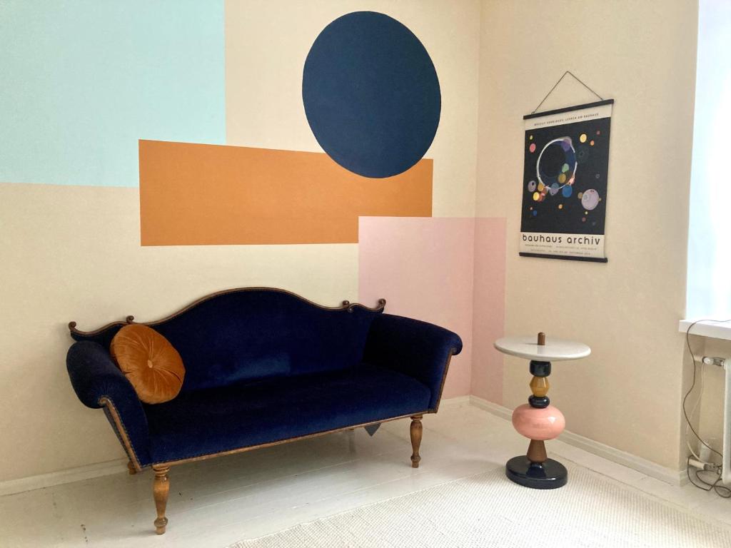 sala de estar con sofá azul y mesa en Spacious (44 sqm) bohemian studio in trendy Kallio en Helsinki