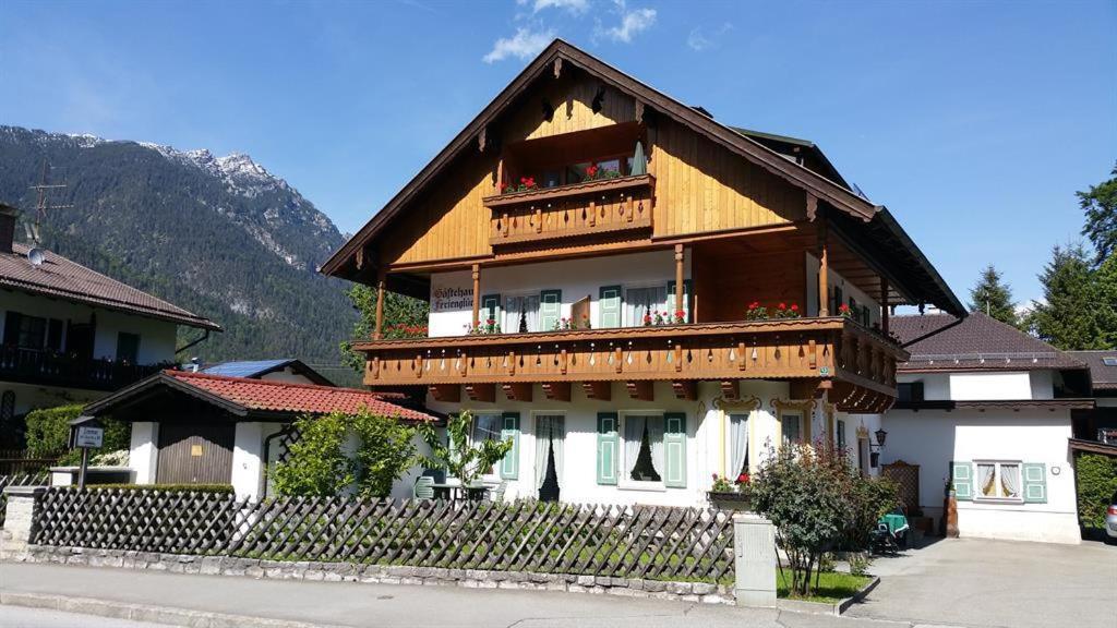 a large wooden house with a fence in front of it at Gästehaus Ferienglück Grainau in Grainau