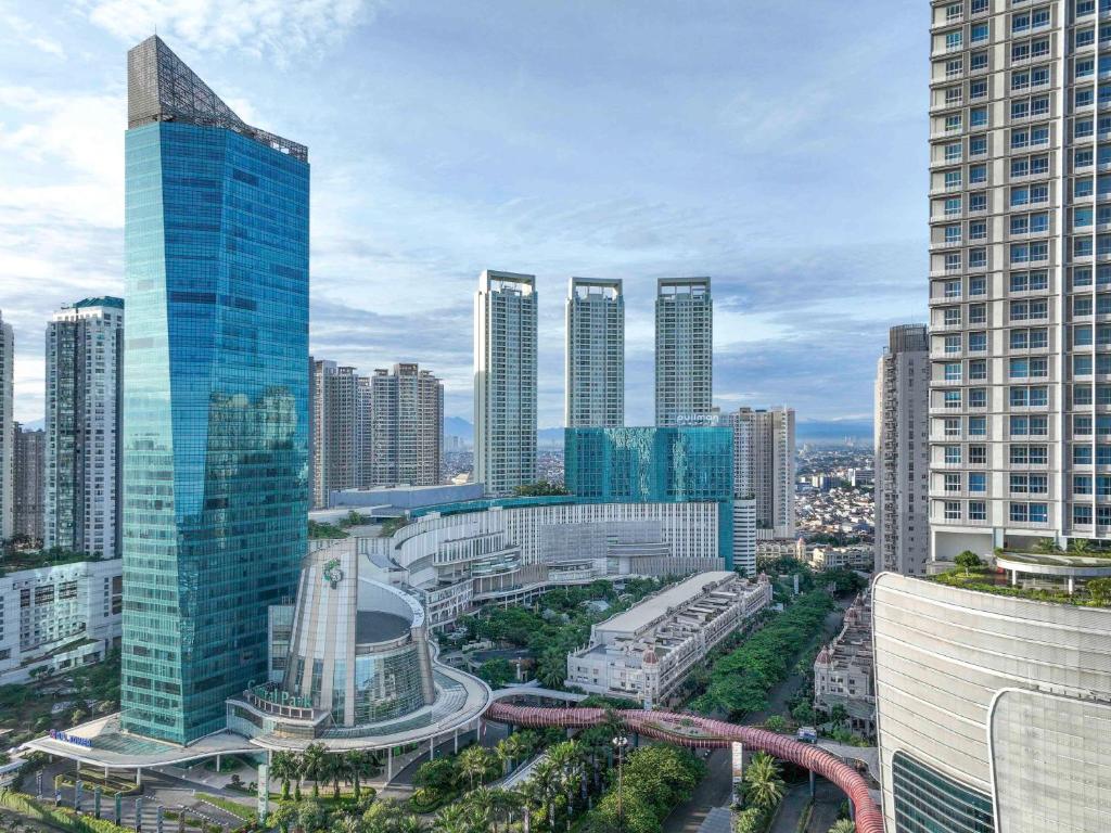 a city skyline with tall buildings and a freeway at Pullman Jakarta Central Park in Jakarta