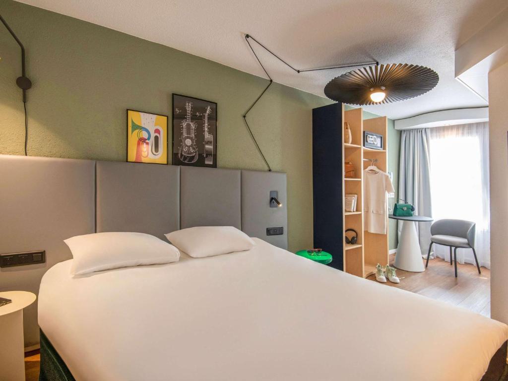 a bedroom with a large white bed and a chair at ibis Cannes Centre in Cannes