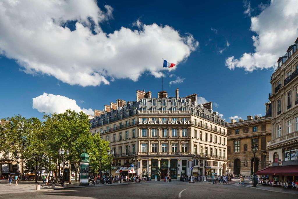 a building with a flag on the top of it at Hôtel du Louvre, in The Unbound Collection by Hyatt in Paris