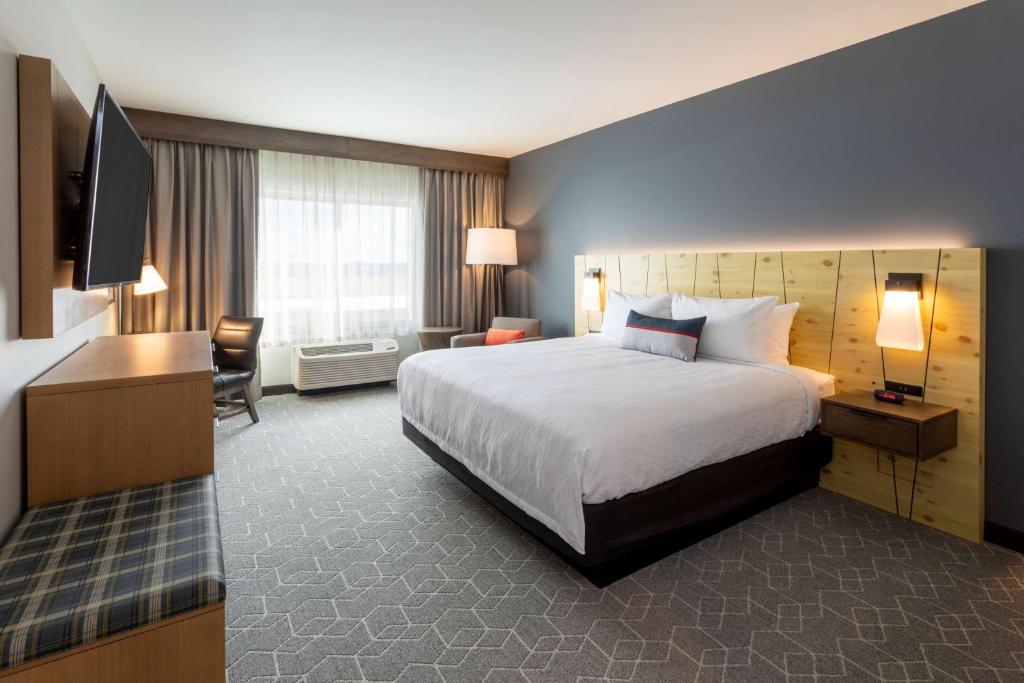a hotel room with a large bed and a television at Running Aces Hotel & Casino, Trademark Collection by Wyndham in Forest Lake