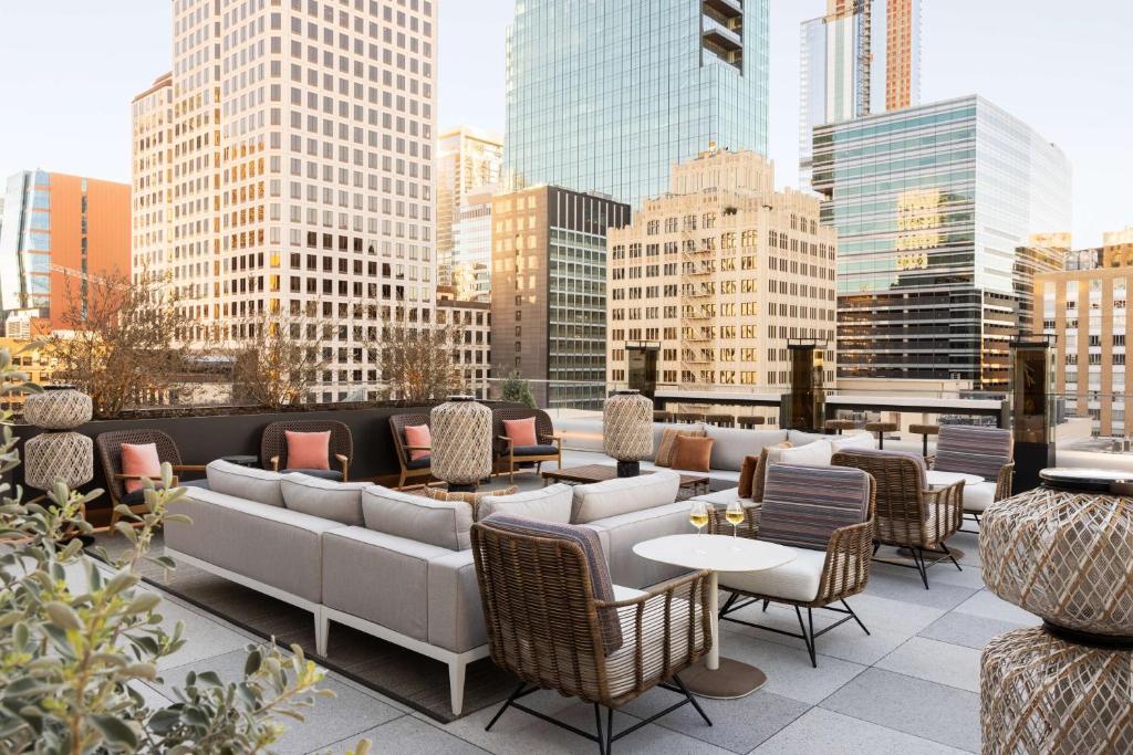 un patio all'ultimo piano con sedie, tavoli e edifici di Hyatt Centric Congress Avenue Austin ad Austin