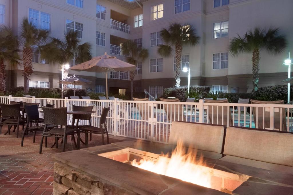 a fire pit in front of a building with tables and chairs at Residence Inn Charleston Riverview in Charleston