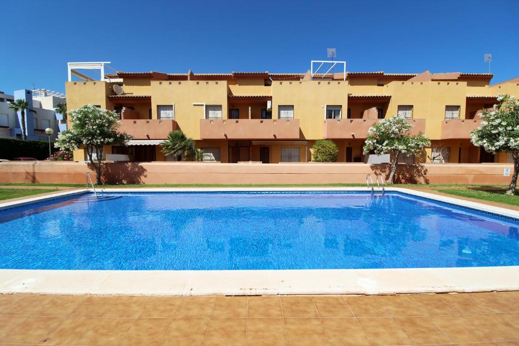 een groot zwembad voor een gebouw bij Nice 3 bedroom Duplex Cabo Roig in Orihuela