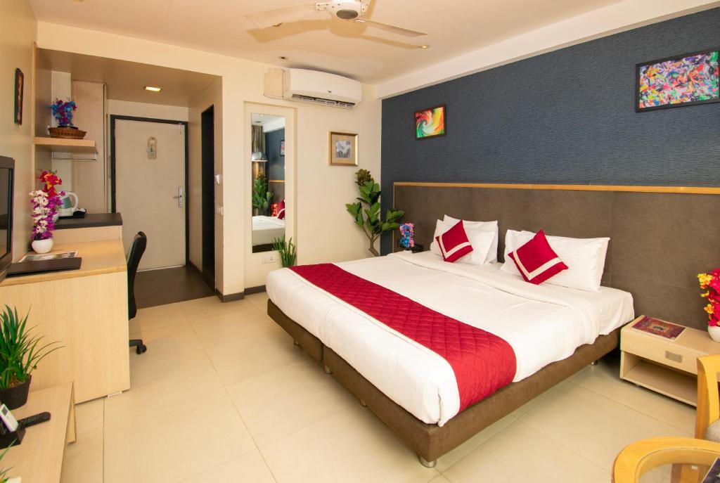a bedroom with a large bed and a bathroom at Octave Koregaon Park in Pune