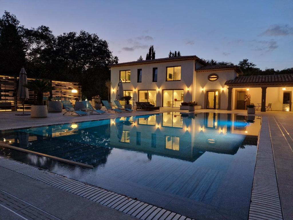 a swimming pool in front of a house at Luxury Zen in Châteauneuf