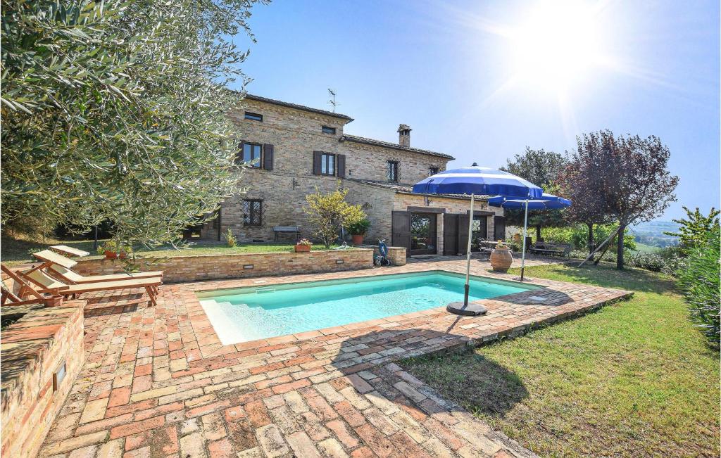 una piscina con ombrellone di fronte a una casa di Villa Chibo a Corridonia