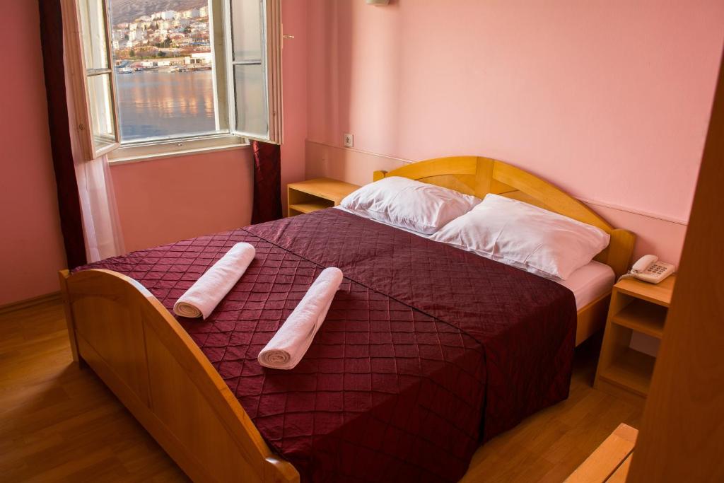 a bedroom with a bed with two pillows on it at Hotel Art in Senj