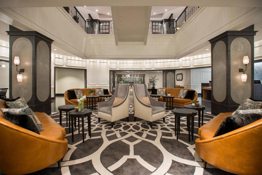 a lobby with couches and tables and chairs at Magnolia Hotel Houston, a Tribute Portfolio Hotel in Houston