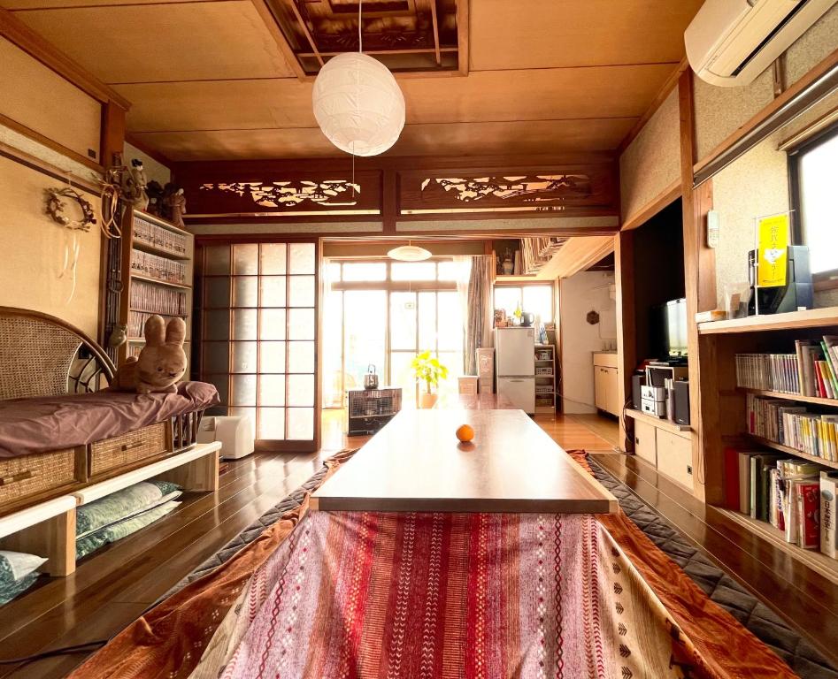 sala de estar con mesa y alfombra grande en AKARIYA Home&Hostel en Karatsu