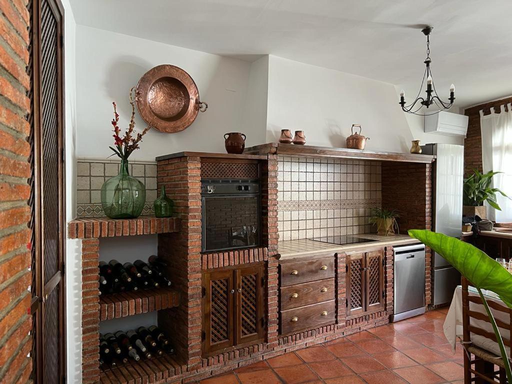 a kitchen with a counter with wine bottles in it at Casa Rural Mijarra **** in Herrera del Duque