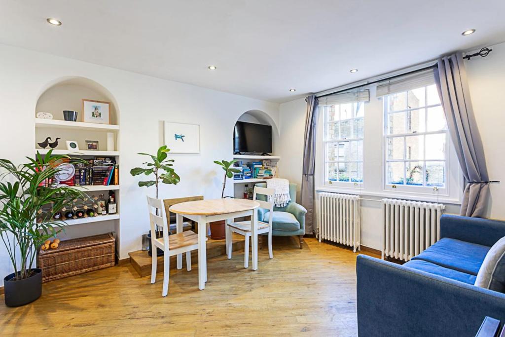 a living room with a table and chairs and a window at Gorgeous Angel Flat in London