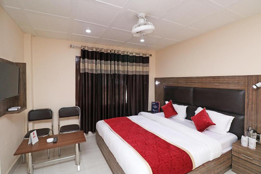 a bedroom with a large bed with red pillows at Hotel Abc Residency in Jawāharnagar