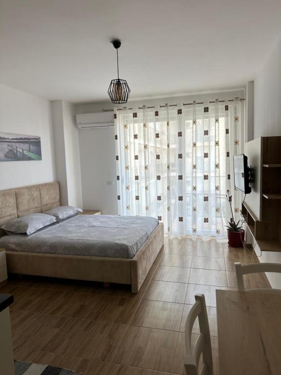 a bedroom with a bed and a large window at Sea View Mario's Studio in Sakës