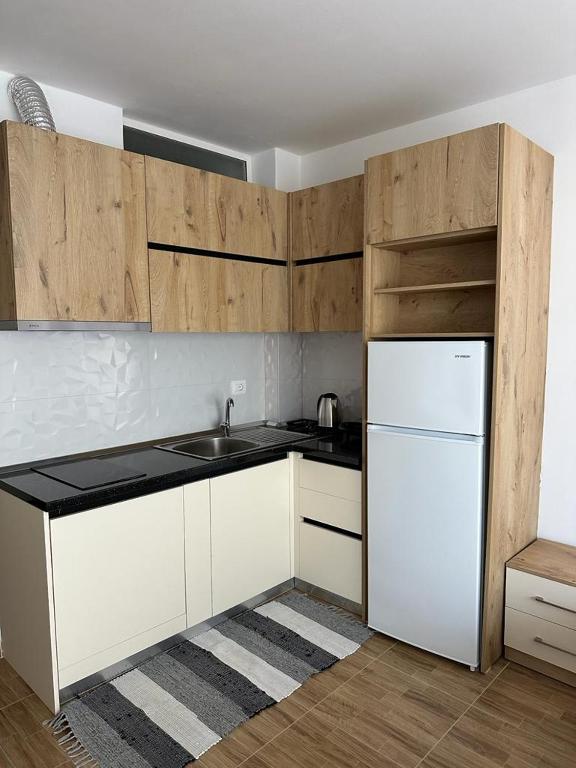 a kitchen with white cabinets and a white refrigerator at Sea View Mario's Studio in Sakës