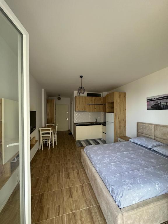 a bedroom with a large bed and a kitchen at Sea View Mario's Studio in Sakës