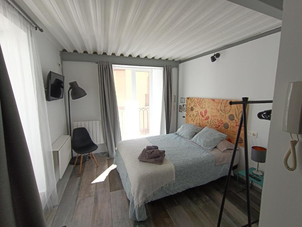 ein Schlafzimmer mit einem Bett und einem großen Fenster in der Unterkunft Estudio con encanto en Casco Antiguo de Burgos P2 in Burgos