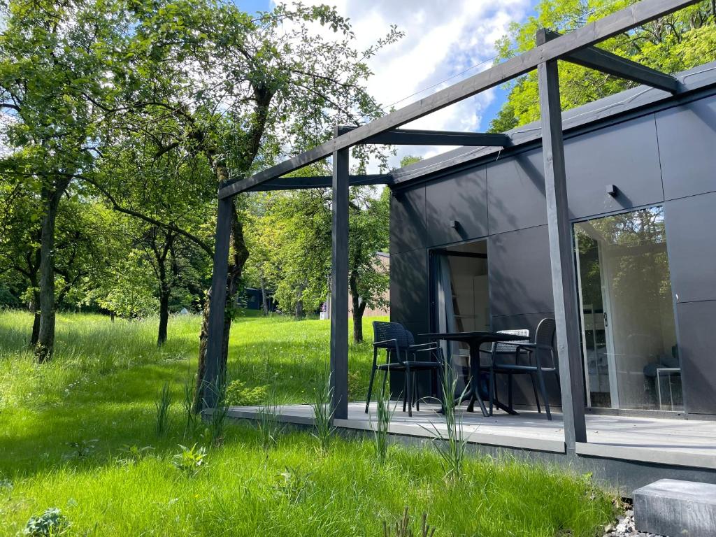 a glass house with a table in the grass at Domki Karpatia BB in Bielsko-Biała