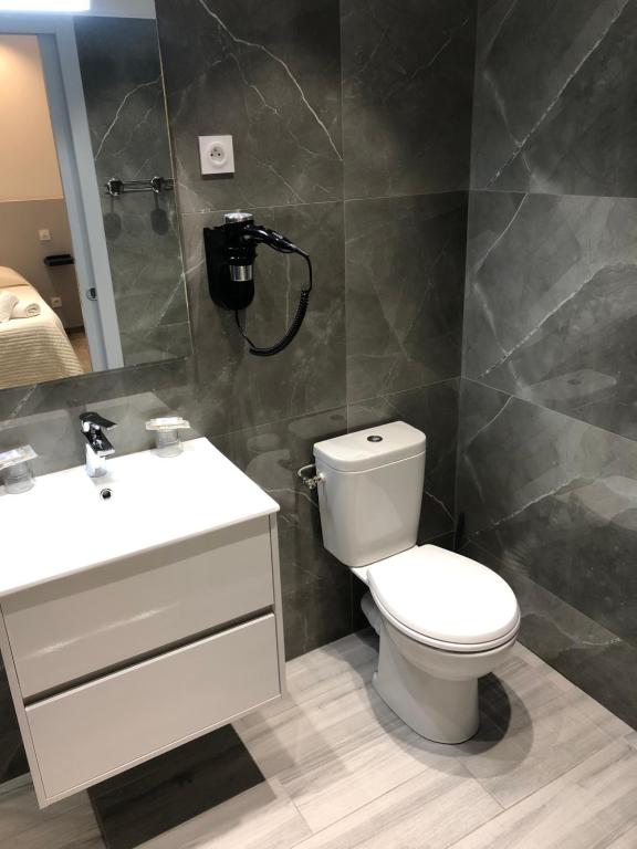 a bathroom with a toilet and a sink and a mirror at Hotel le Dauphin in Ajaccio