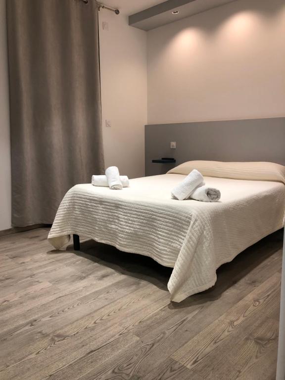 a bedroom with a bed with two towels on it at Hotel le Dauphin in Ajaccio