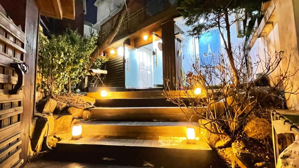 un escalier menant à une maison éclairée dans l'établissement Jeong House, à Séoul