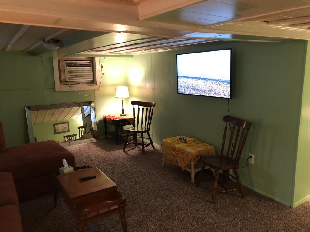 sala de estar con sofá y TV de pantalla plana en Rustic BEACH FRONT Basement Apt, Pet Friendly Wi-Fi apts en North Camellia Acres