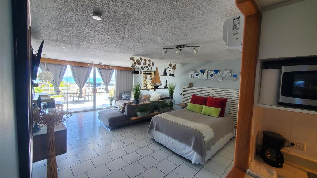 ein Schlafzimmer mit einem Bett, einem Sofa und einem TV in der Unterkunft Cozy Apartment, Ocean Front in Fajardo