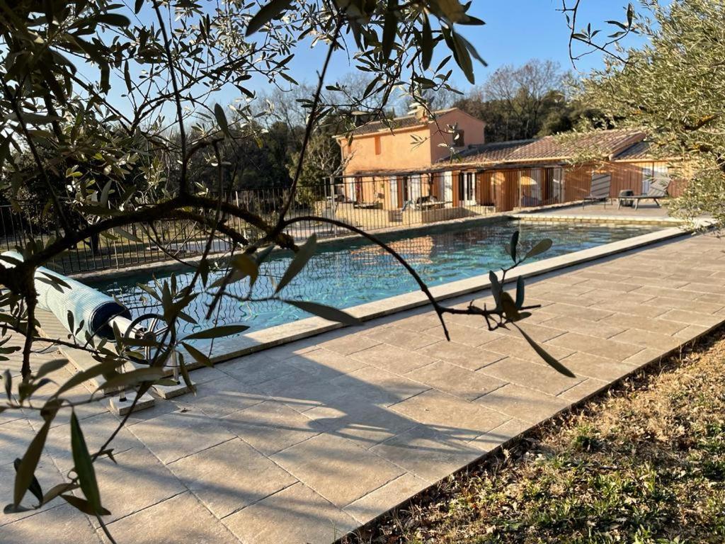 una piscina di fronte a una casa di Les micocouliers a Lagnes