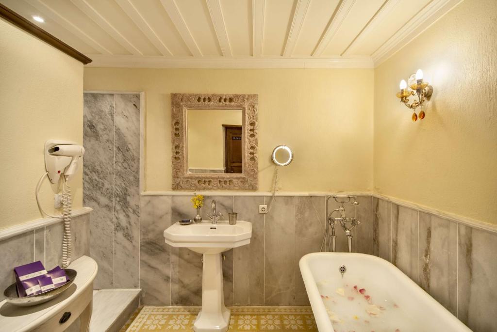a bathroom with a sink and a bath tub at Gullu Konaklari in Selçuk