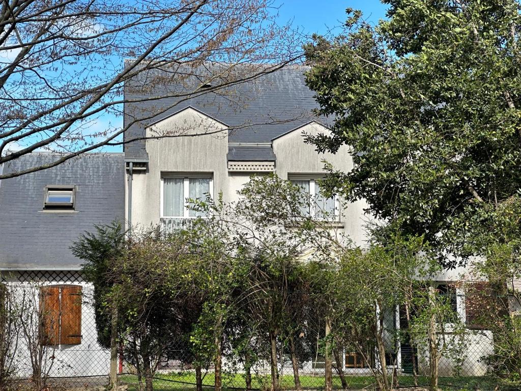 ヴィルジュイフにあるMaison de Longde - chambreの木々が目の前に広い白い家