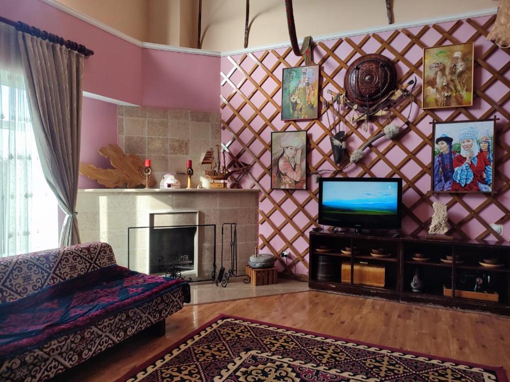 a living room with a fireplace and a tv at Tagaytay Karakol Hotel in Karakol