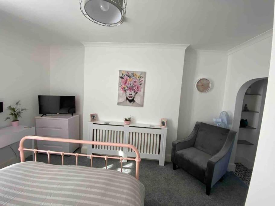 a bedroom with a bed and a chair and a television at Chic & Cosy Studio Apartment in Southampton