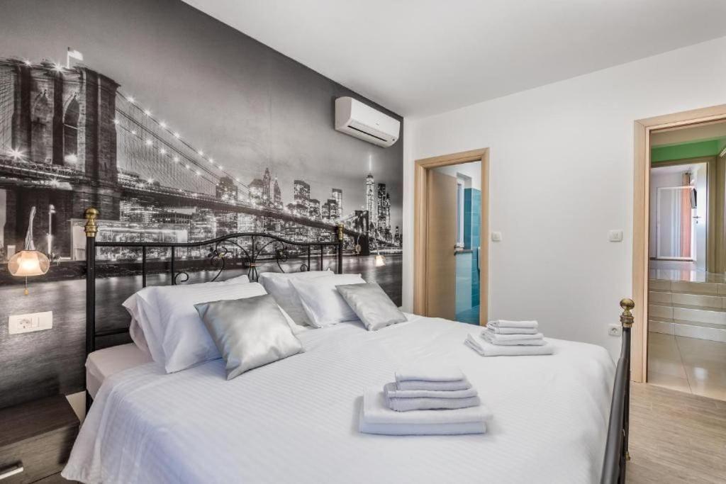 ein Schlafzimmer mit einem weißen Bett und Handtüchern darauf in der Unterkunft Villa Ma vie en rose, un havre de paix in Kunj