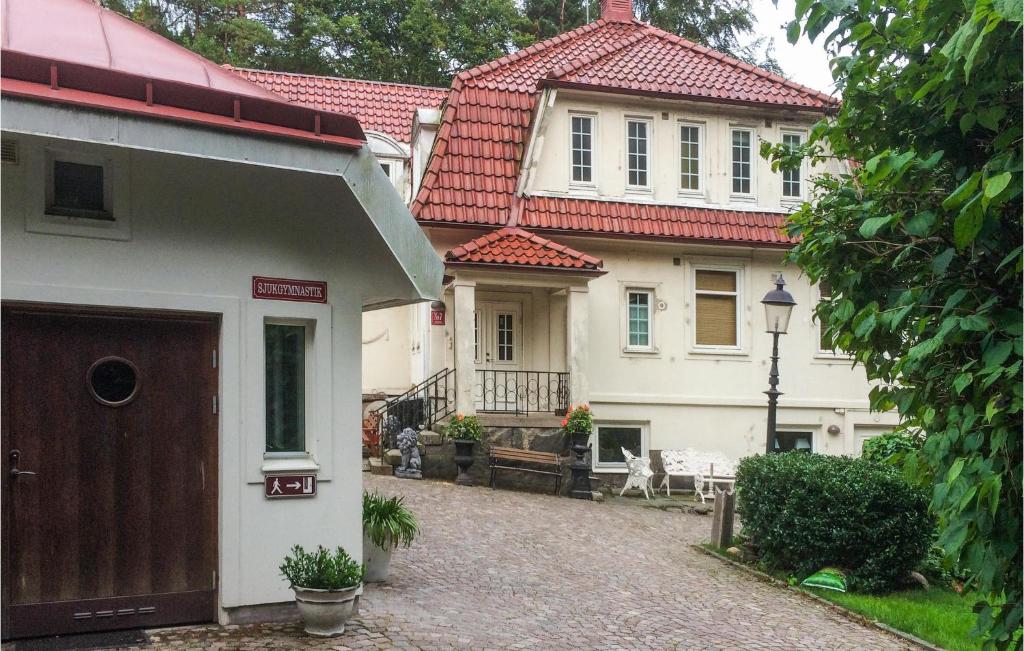 uma grande casa branca com um telhado vermelho em Gorgeous Apartment In Bors With Wifi em Borås