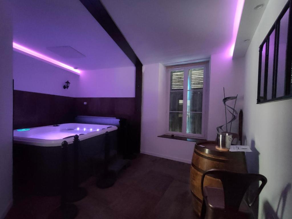 a purple room with a tub and a window at #FER RÊVER 63# Jacuzzi #Salle de Sport en supplément et sur demande#Musculation in Thiers