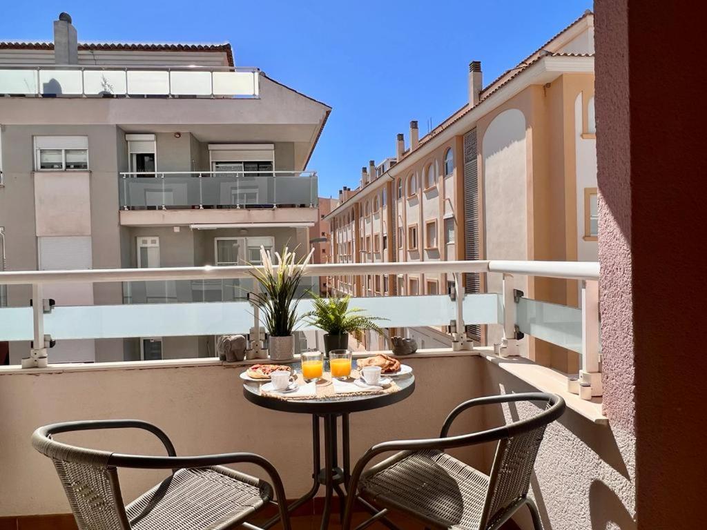 a table on a balcony with two chairs and orange juice at Casa Pepa by Sun & Sea Homes in Moraira