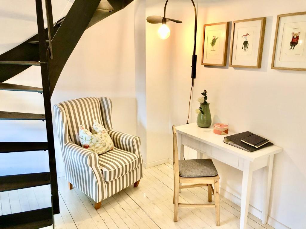 ein Wohnzimmer mit einem Stuhl und einem Schreibtisch in der Unterkunft Ferienwohnung Ludwigstrasse in Nürnberg