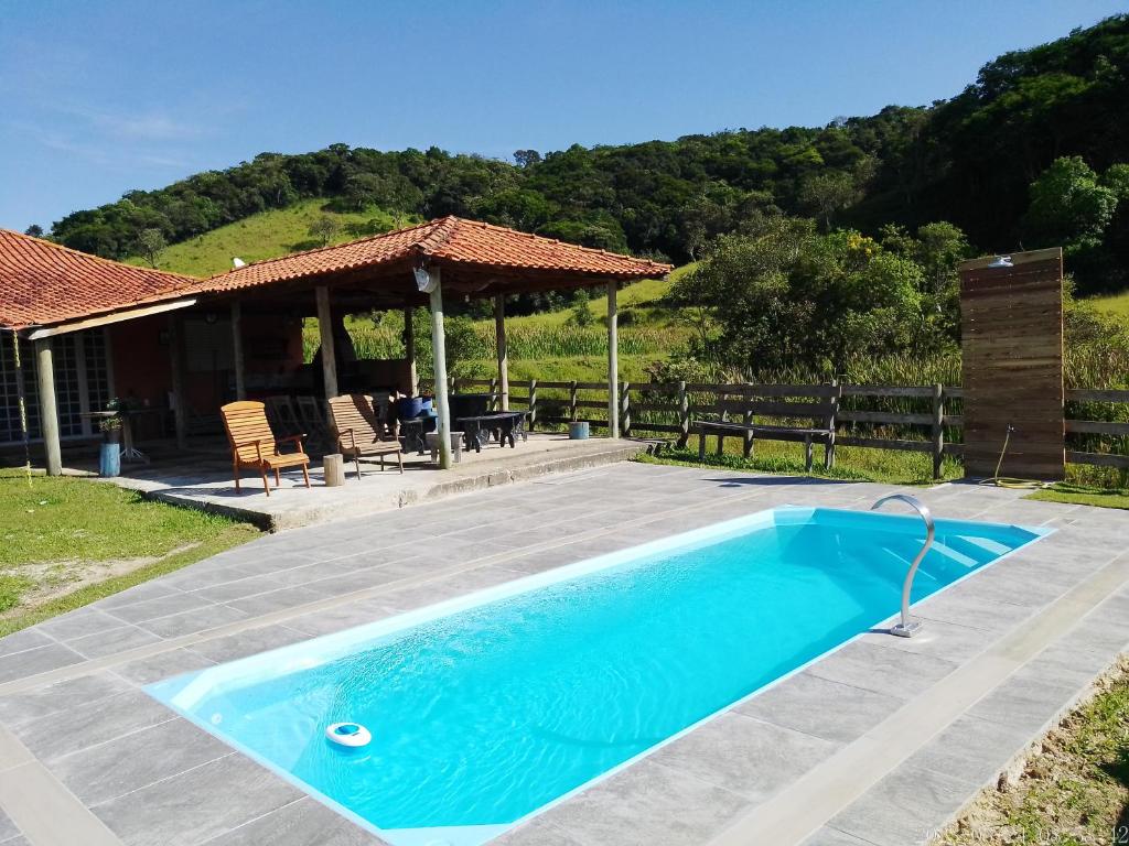 une piscine bleue en face d'une maison dans l'établissement sitio santa Eulalia, à Cunha