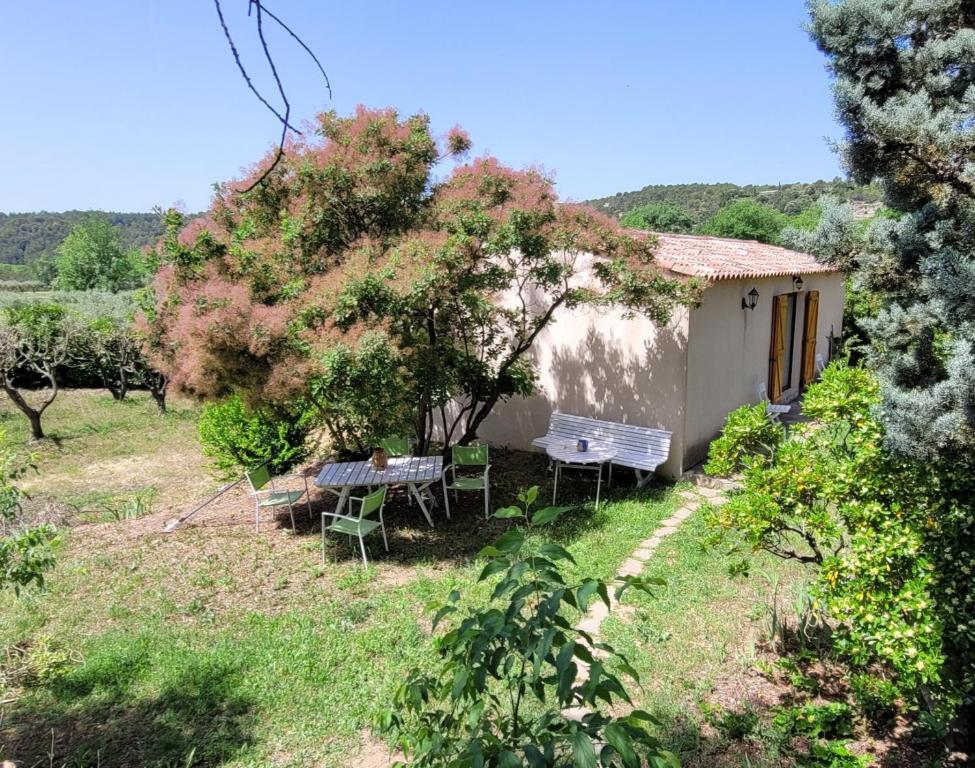 dom ze stołem i krzesłami na dziedzińcu w obiekcie Maison dans la Provence Verte w mieście Cotignac