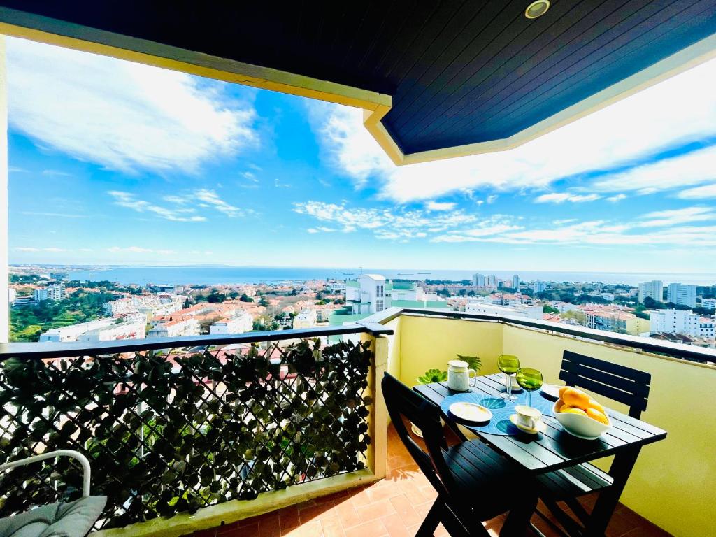 a balcony with a table with a view of a city at Studio Cascais with Sea view in Cascais