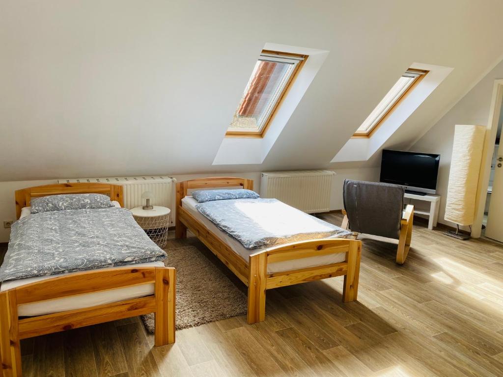two beds and a chair in a room with skylights at Ferienwohnung Mühle in Rietschen