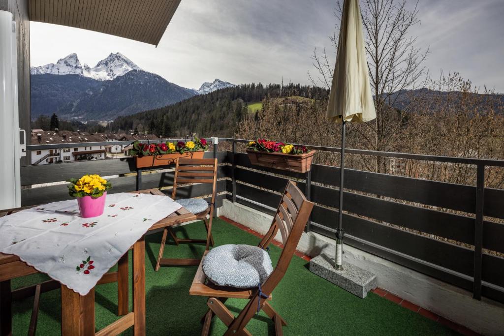 a balcony with a table and chairs and mountains at FeWo Berkristall mit Hallenbad in Berchtesgaden