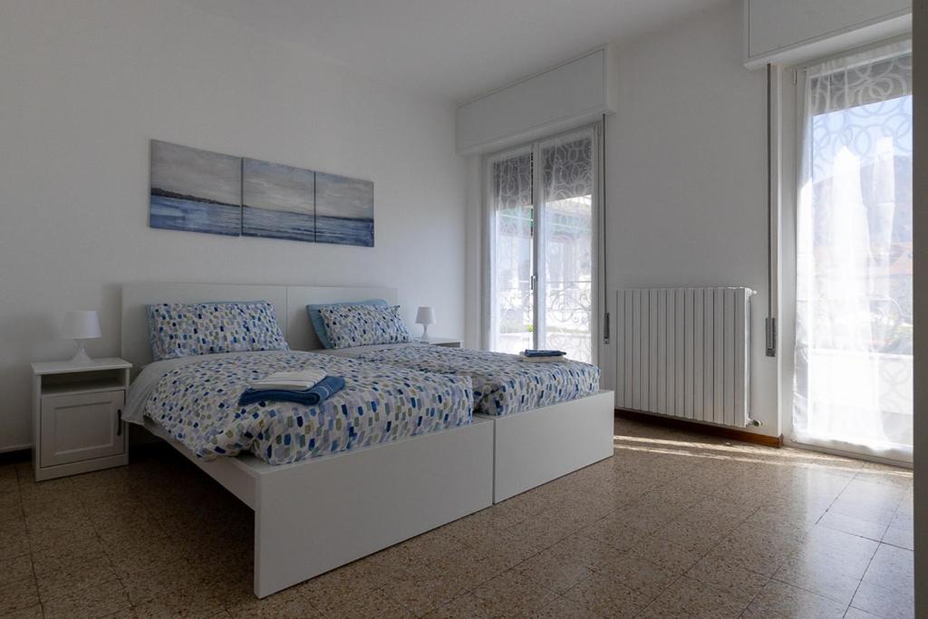 a bedroom with a large bed with blue and white sheets at Casa Margherita Bellagio in Bellagio