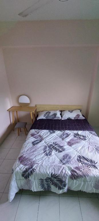 a bedroom with a bed with a purple comforter at Homestay nipah in Bayan Lepas