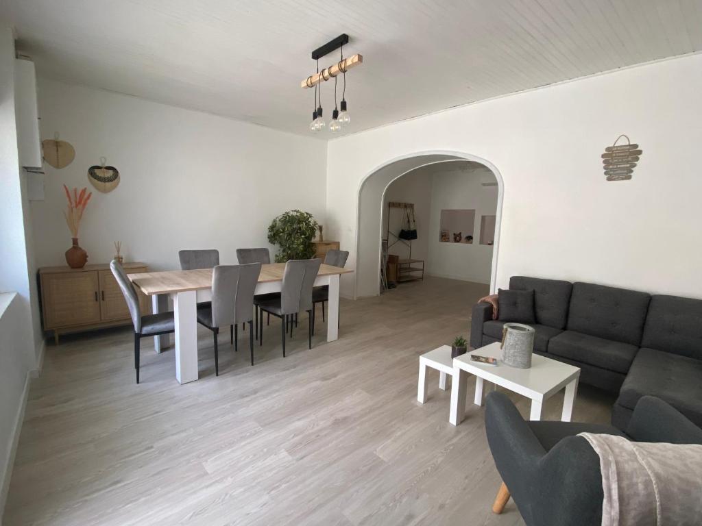 uma sala de estar com um sofá, uma mesa e cadeiras em Maison de village -Luberon - Villelaure em Villelaure