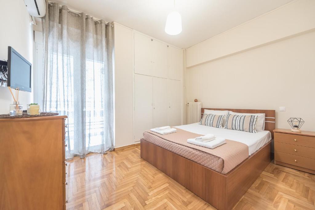 1 dormitorio con 1 cama y TV en Spacious Cozy Apartment in Athens, en Atenas