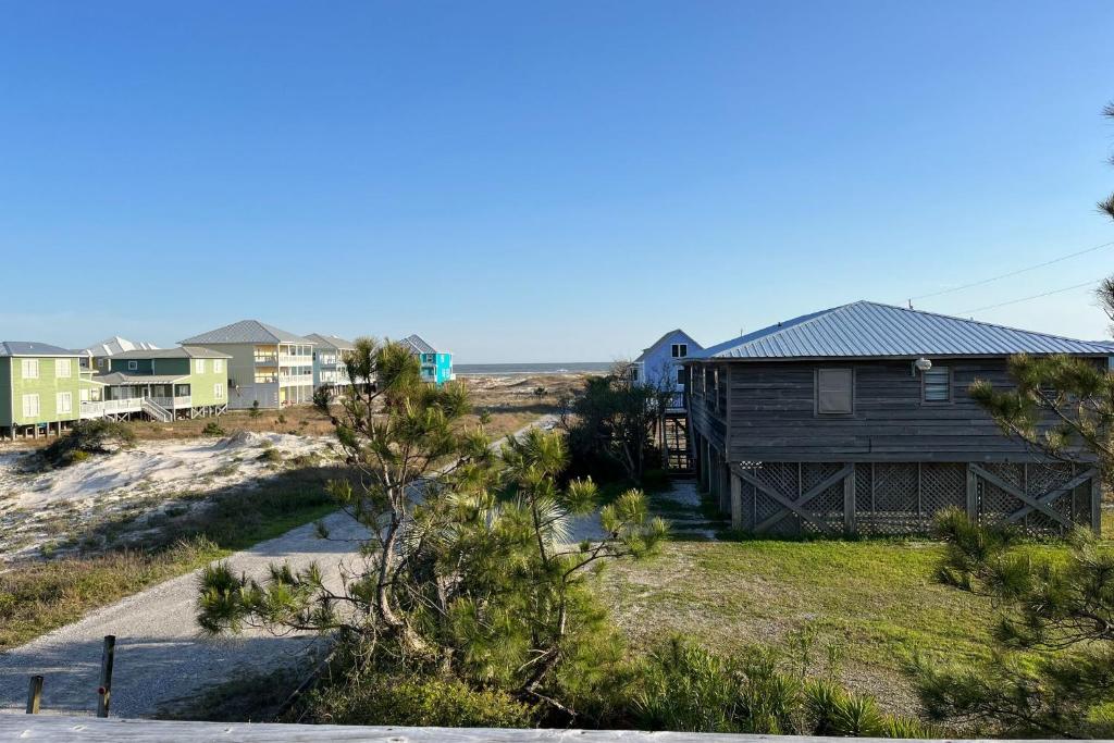 een huis op het strand met huizen op de achtergrond bij Whitesands South Relax in comfort at this duplex within walking distance of the beach in Gulf Shores
