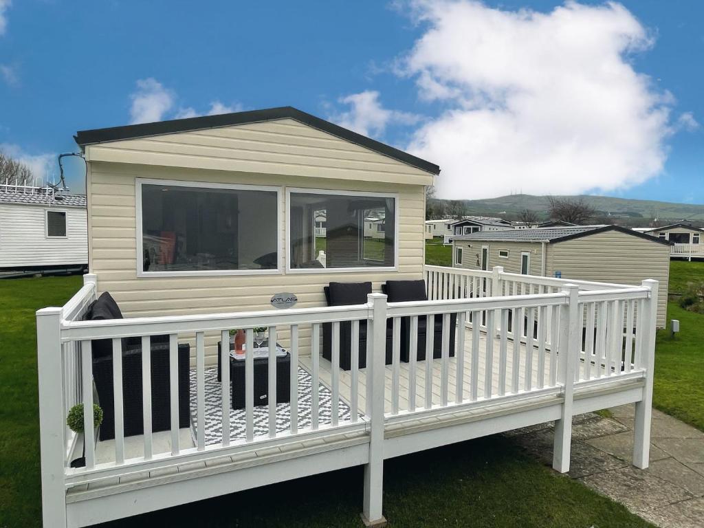 a house with a white railing on a deck at Atlas By The Sea - Craig Tara, Ayr in Ayr